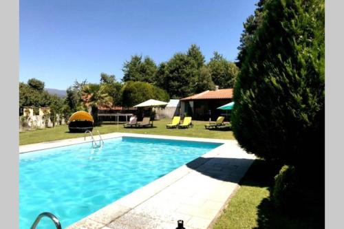 a swimming pool in the yard of a house at Holidays “Villa Familia Silva” in Ribeiradio