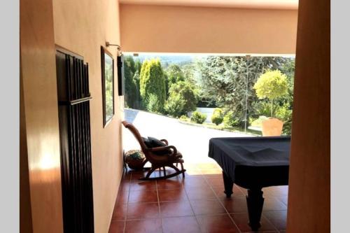 a room with a piano and a view of a garden at Holidays “Villa Familia Silva” in Ribeiradio
