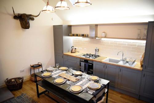a kitchen with a table with plates on it at Lodge on the Loch in Sconser