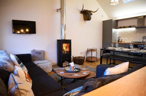 a living room with a couch and a fireplace at Lodge on the Loch in Sconser