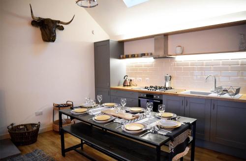 a kitchen with a table with plates and glasses on it at Lodge on the Loch in Sconser