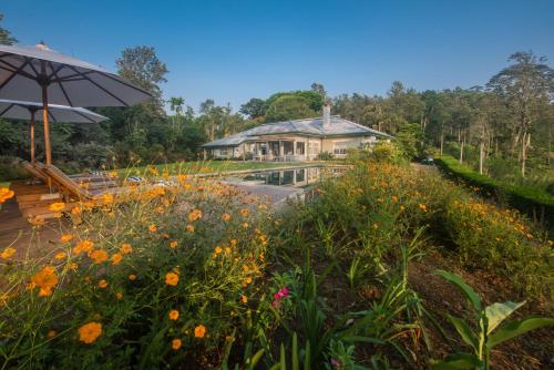 a garden with flowers and a house in the background at Nine Skies in Ella