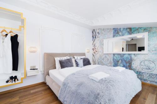 a white bedroom with a bed and a mirror at Modern Studio Węgierska Cracow by Renters in Krakow
