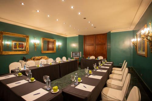 a conference room with long tables and white chairs at Sercotel Palacio de Tudemir in Orihuela