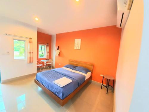 1 dormitorio con paredes de color naranja y 1 cama. en The Moonlight Resort en Ban Chang