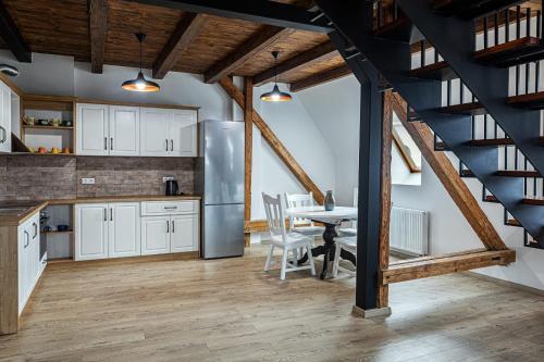a kitchen and dining room with a table and a staircase at Apartament The Bricks 1903 in Bistriţa