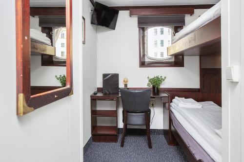 a small room with a desk and a bed and bunk beds at Mälardrottningen Yacht Hotel in Stockholm