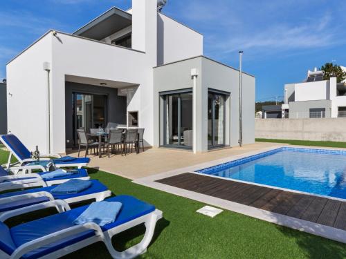 Villa con piscina y tumbonas azules en Luxury villa with private heated pool en Foz do Arelho