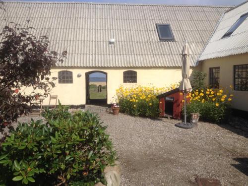 a white building with a door and some flowers at Stutteri Ahl near beach and town in Ebeltoft