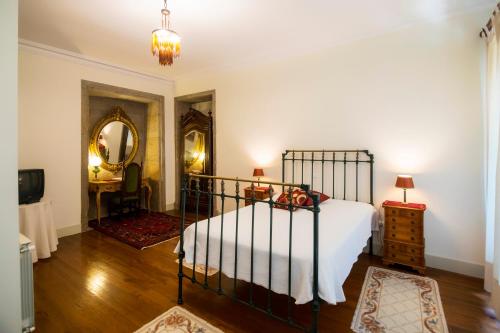 a bedroom with a bed and a mirror at Casa do Condado de Beirós in São Pedro do Sul