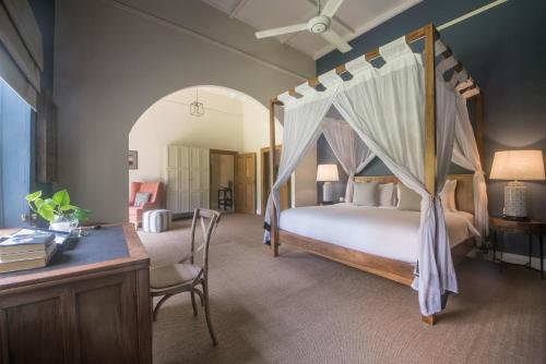a bedroom with a canopy bed and a desk at Nine Skies in Ella