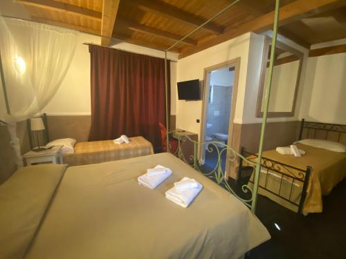 una camera d'albergo con due letti e uno specchio di Park Hotel Serenissima a Sacrofano
