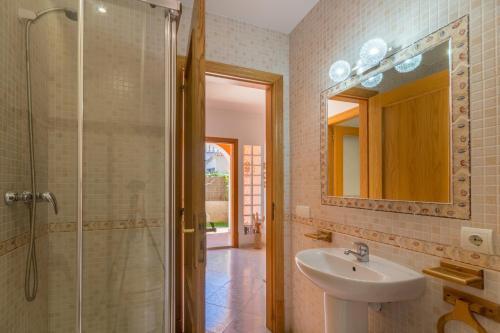 een badkamer met een wastafel, een douche en een spiegel bij Bahia Grande - 314016 in Badia Blava