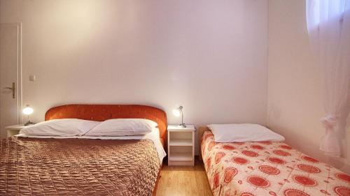 two beds in a small room with two lamps at Apartment Villa Mare2 with pool, sea view and hydromassage in Banjole