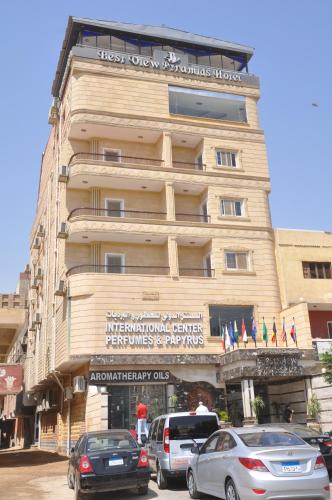 a building with cars parked in front of it at Best View Pyramids Hotel in Cairo