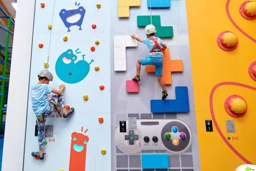 two young boys playing on a climbing wall at Stacja Nowa Gdynia Bed & Breakfast Aquapark in Łódź