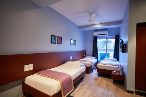 three beds in a room with blue walls at Aureole Mrida - A Boutique Hotel in Lonavala