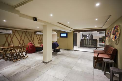 a lobby with chairs and tables and a kitchen at Aureole Mrida - A Boutique Hotel in Lonavala