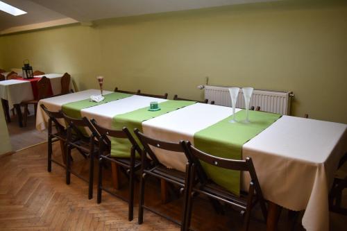 克拉科夫的住宿－格林旅館，一间设有两张桌子的房间,配有绿色和白色的桌布