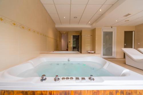 a large bath tub in a bathroom with a tub at Hotel Rosaleda del Mijares in Montanejos