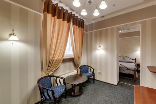 a room with a table and two chairs and a bed at Soborniy Hotel in Zaporozhye