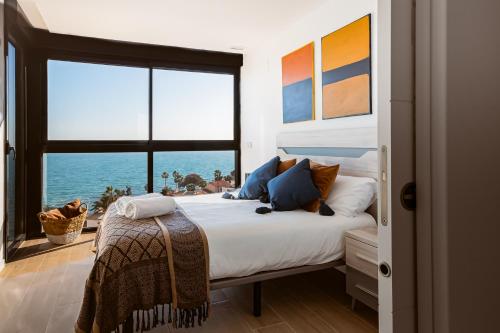 a bedroom with a bed with a view of the ocean at Modern sea front Reef in Alicante