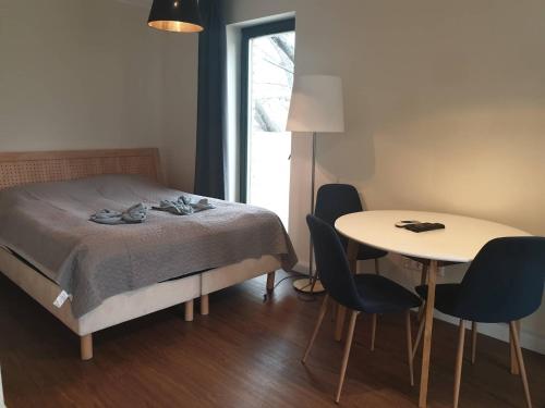 布達佩斯的住宿－Éjjeli Bagoly Étterem és Panzió，卧室配有一张床和一张桌子及椅子