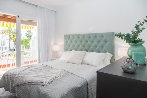 Schlafzimmer mit einem großen Bett mit blauem Kopfteil in der Unterkunft Stylish Penthouse 2 pools & next to beach - RDR204 in Marbella
