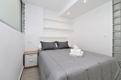 une chambre avec un lit et un mur blanc dans l'établissement Albatros 14-10 Estudio Levante Beach, à Benidorm