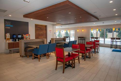 a restaurant with tables and chairs and a bar at Holiday Inn Express & Suites Tonawanda - Buffalo Area by IHG in Tonawanda