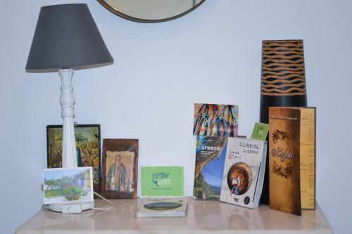 a table with a lamp and books on it at Anna's Family Home in Leonidion