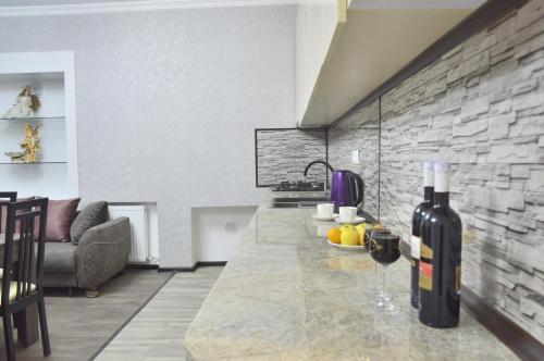 Una cocina con un mostrador con una botella de vino. en Mtatsmindaze, en Tiflis