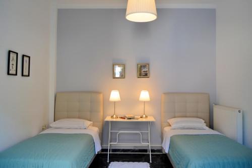 a room with two beds and a table with lamps at Anna's Family Home in Leonidion