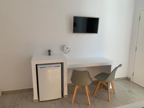 a room with a table and two chairs and a tv at Chill Out Studio in Mýkonos City