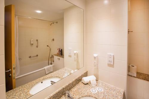 a bathroom with two sinks and a large mirror at Maldron Hotel Wexford in Wexford