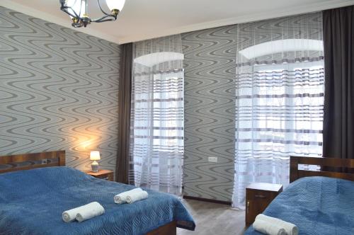 Un dormitorio con una cama azul con toallas. en Mtatsmindaze en Tiflis