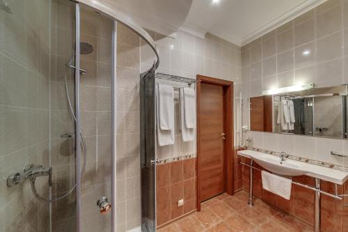y baño con ducha, lavamanos y ducha. en Soborniy Hotel, en Zaporozhye