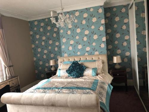 a bedroom with a bed with blue floral wallpaper at Southfield lodge in Middlesbrough