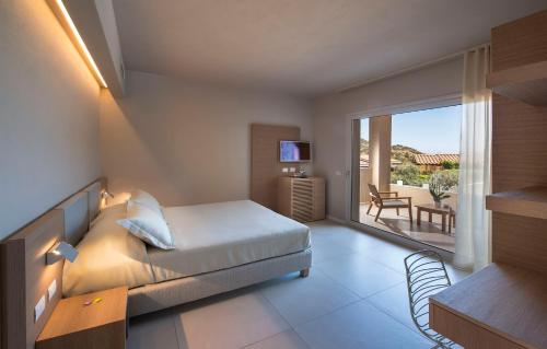 a hotel room with a bed and a balcony at Domu Simius Hotel in Villasimius