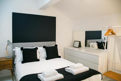 a bedroom with a white bed with towels on it at Regent House deluxe 1 bedroom apartment in Harrogate