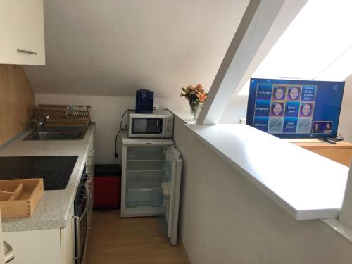 a kitchen with a counter with a microwave and a sink at 45 m² Maisonette-Wohnung in Uni-/Hauptbahnhofnähe in Duisburg