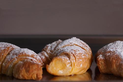 three croissants are covered in powdered sugar on a table at Hotel San Germano in Piedimonte San Germano