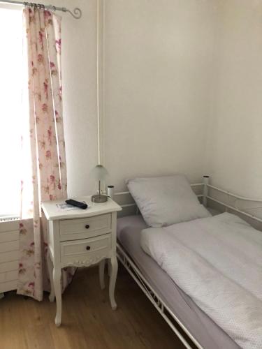 a bedroom with a bed and a table with a nightstand at Gast und Hof Spittel in Langenbruck