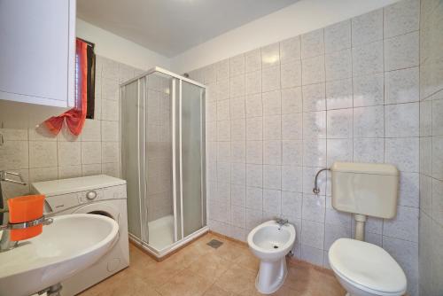 a bathroom with a toilet sink and a shower at Apartment Villa Mare3 with pool, sea view and hydromassage in Banjole