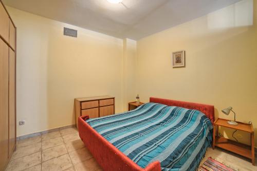 a bedroom with a bed with a blue blanket at Apartment Villa Mare3 with pool, sea view and hydromassage in Banjole