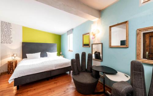 フォルカッハにあるHotel Turmdiebのベッドルーム1室(ベッド1台、テーブル、椅子付)