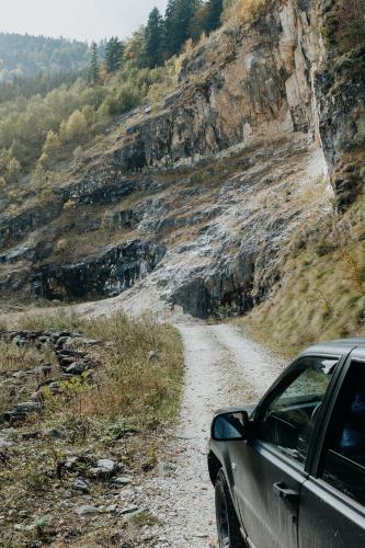 a car parked on a dirt road next to a mountain at Boutique Guesthouse „Domizil“, Valea Porumbacului in Porumbacu de Sus
