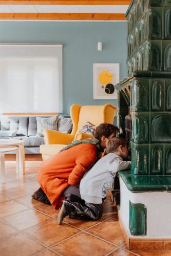 a man and two children are playing in a fireplace at Boutique Guesthouse „Domizil“, Valea Porumbacului in Porumbacu de Sus