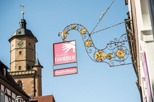una señal en el lateral de un edificio con una torre de reloj en Hotel Turmdieb, en Volkach