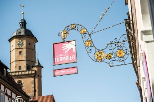 ein Schild an der Seite eines Gebäudes mit einem Uhrturm in der Unterkunft Hotel Turmdieb in Volkach